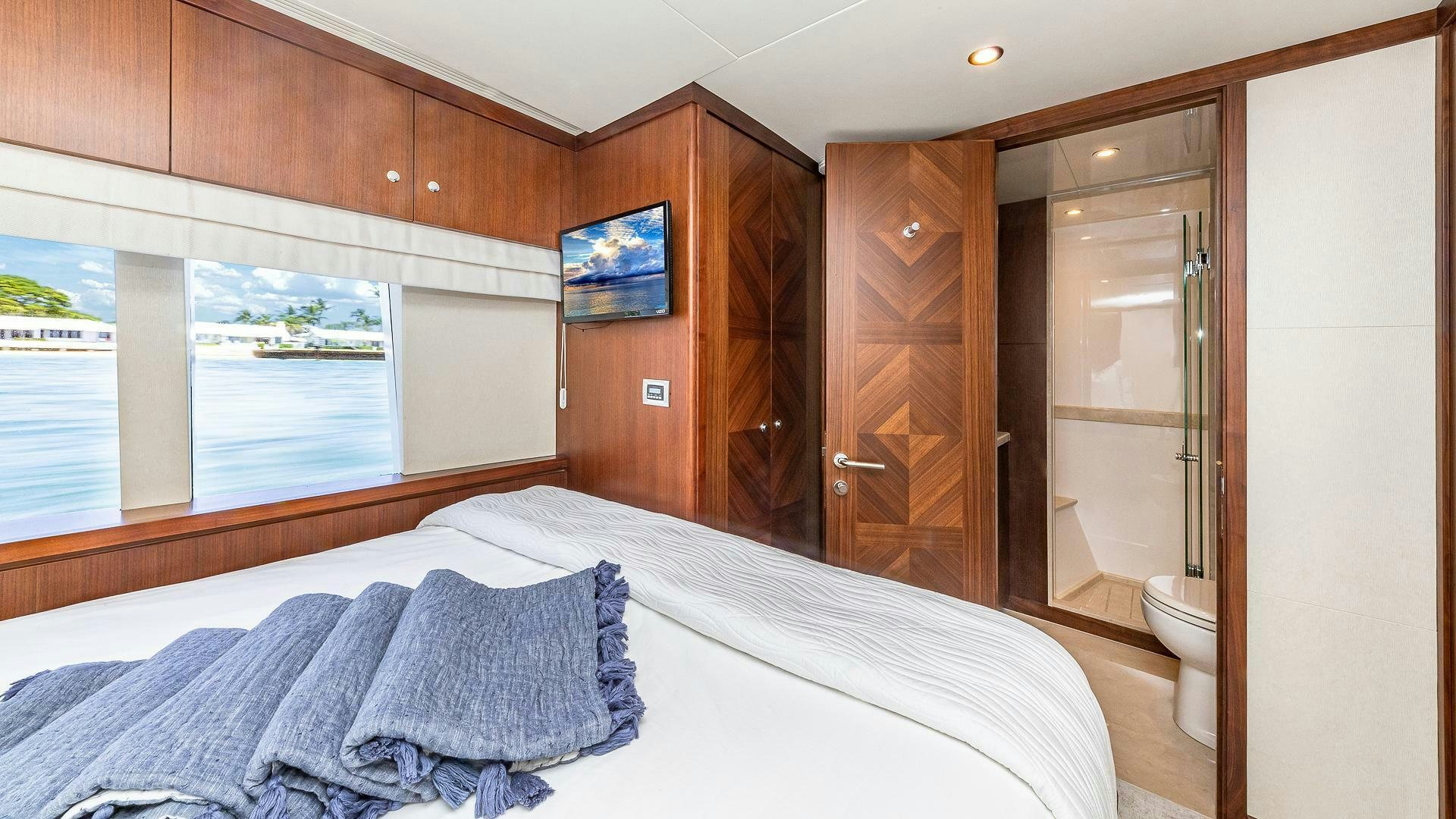 a bedroom with a bed and a wood door aboard NOW WE KNOW Yacht for Sale