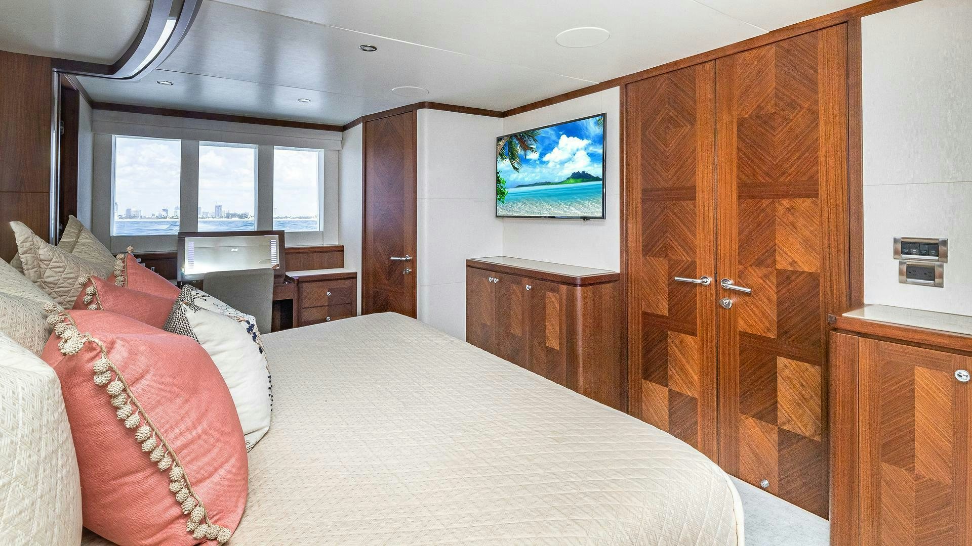 a bed with pillows and a wooden cabinet in a room aboard NOW WE KNOW Yacht for Sale