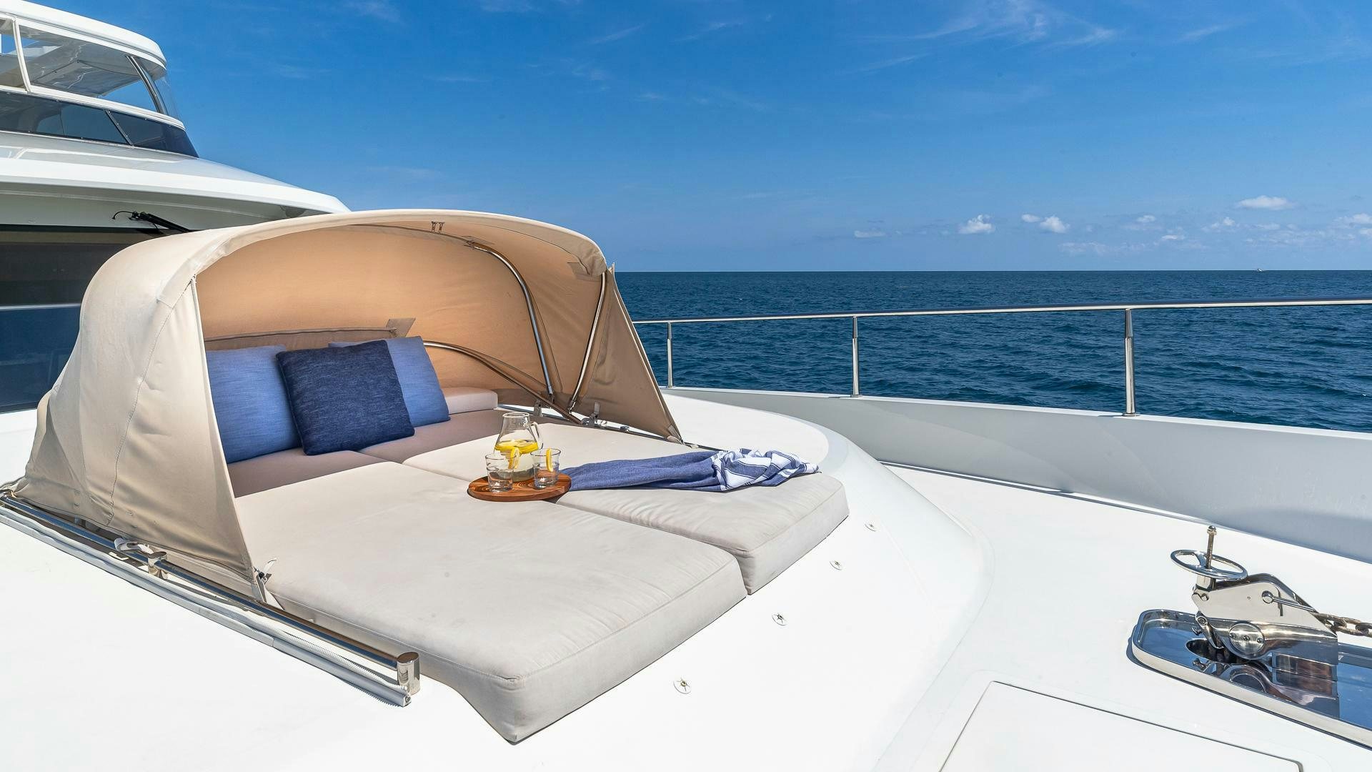 a boat with a drink and a book on the front aboard NOW WE KNOW Yacht for Sale