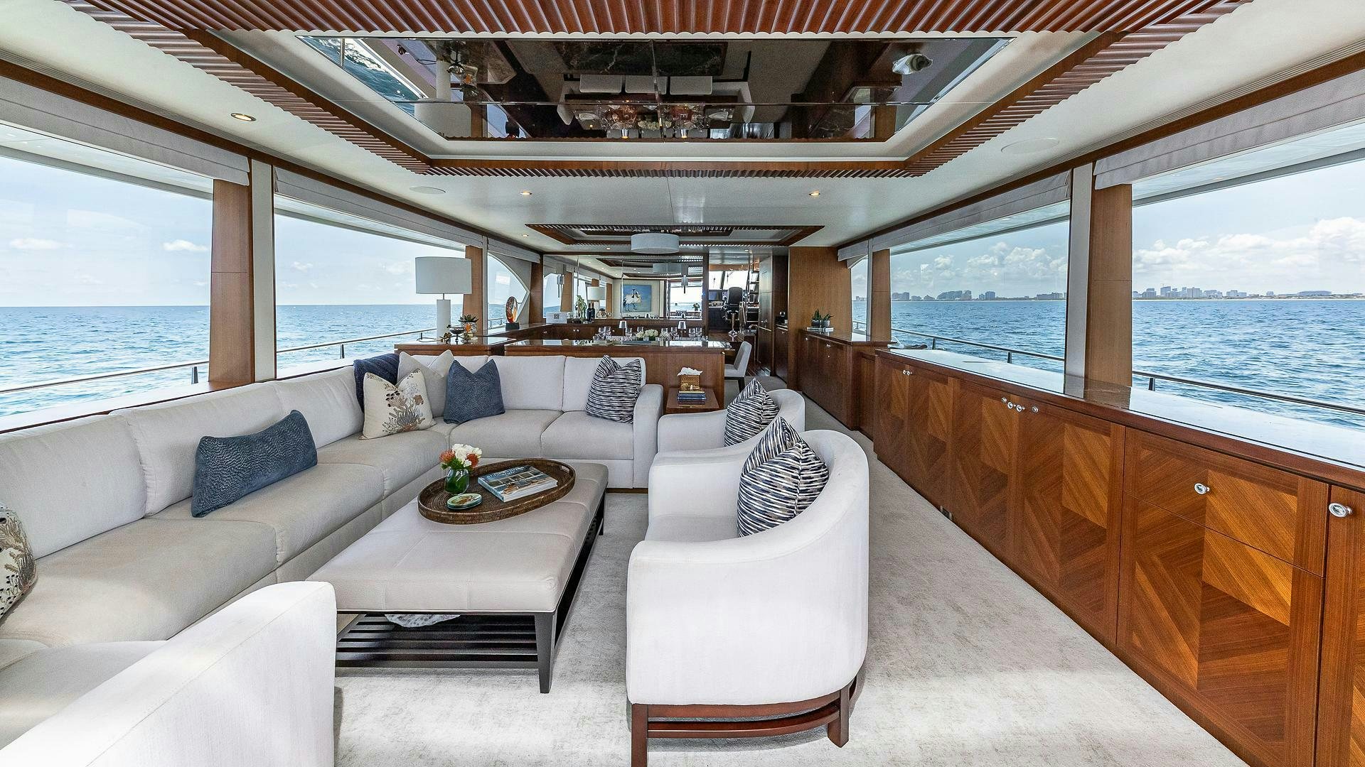 a living room with a large window overlooking the ocean aboard NOW WE KNOW Yacht for Sale