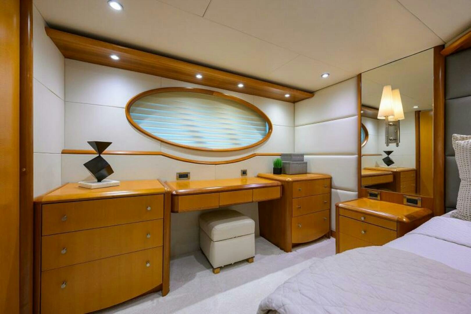 a room with a large mirror above a bed and a desk aboard LIVING THE DREAM Yacht for Sale