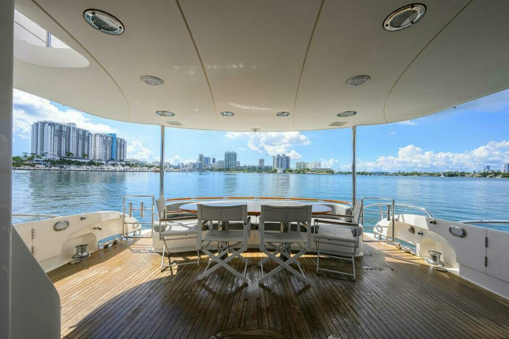 a deck with chairs and tables on it by a large body of water aboard LIVING THE DREAM Yacht for Sale
