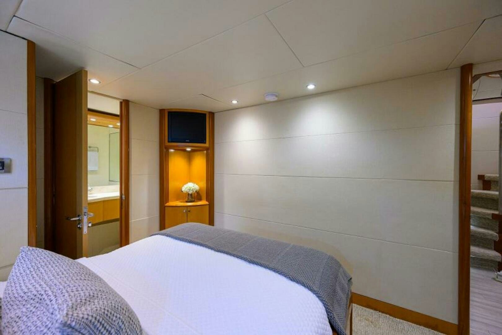 a bedroom with a bed and a tv on the wall aboard LIVING THE DREAM Yacht for Sale