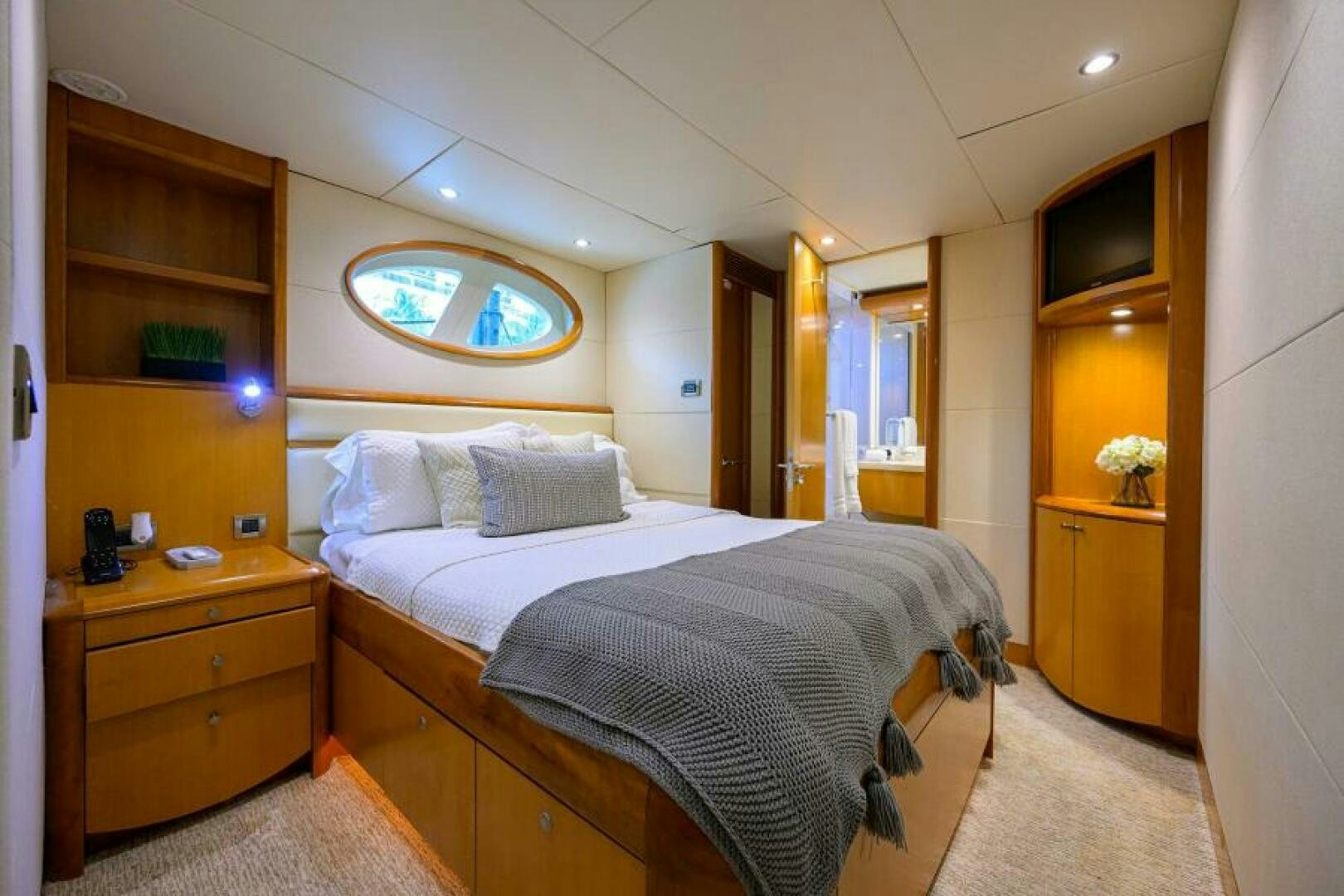 a bedroom with a bed and a dresser aboard LIVING THE DREAM Yacht for Sale