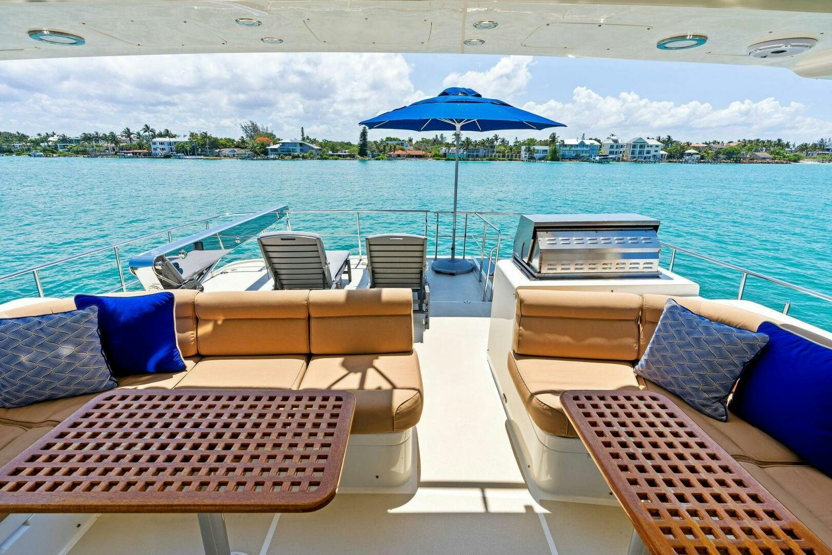 a group of lounge chairs on a beach with an umbrella in the background aboard RELENTLESS Yacht for Sale
