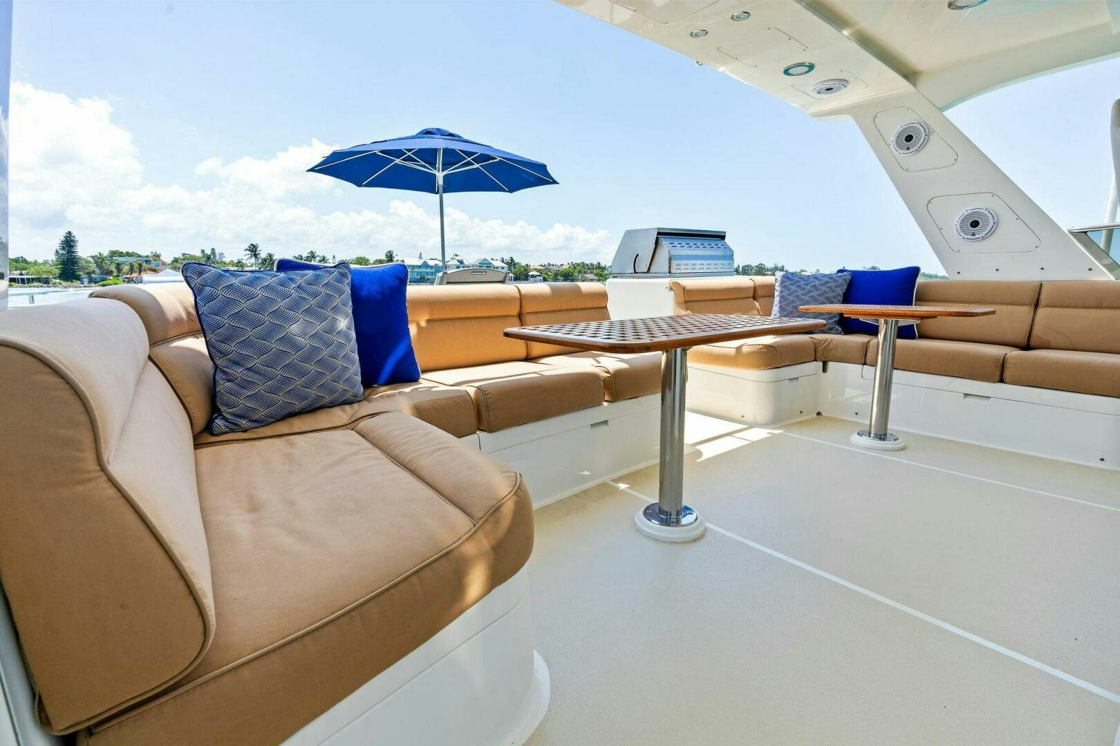 a lounge area with a table and chairs and an umbrella aboard RELENTLESS Yacht for Sale