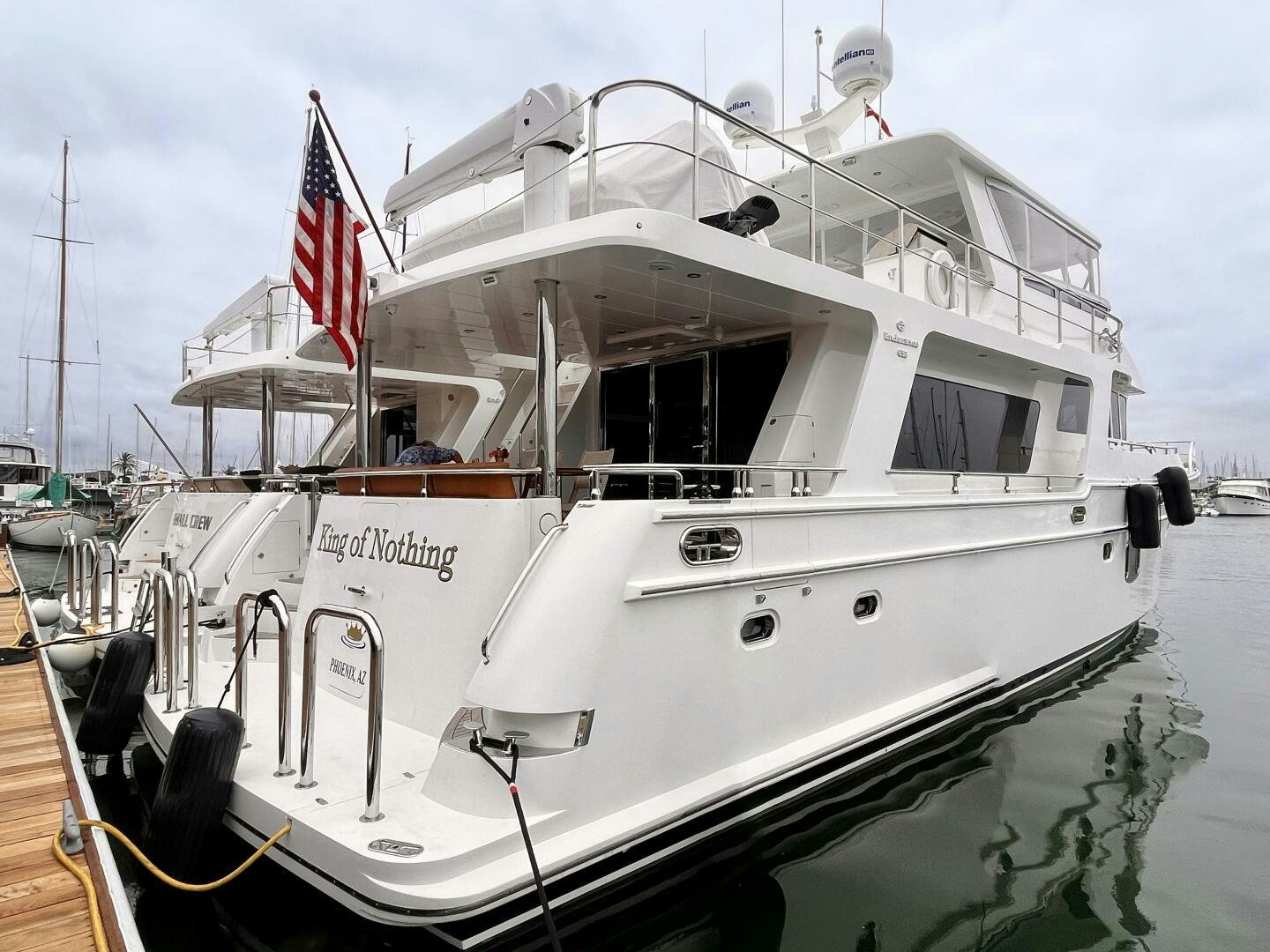 a large white boat with a flag on the front aboard KING OF NOTHING Yacht for Sale