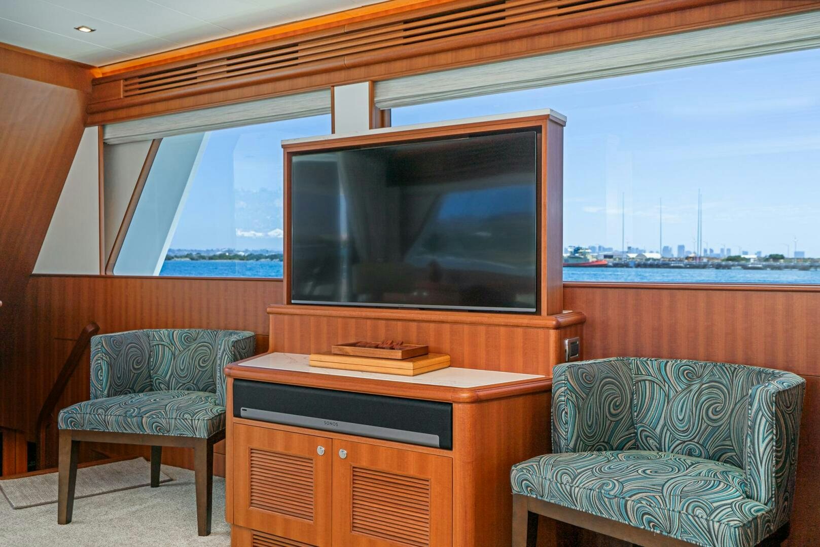 a tv on a stand in a room with a couch and a chair aboard KING OF NOTHING Yacht for Sale