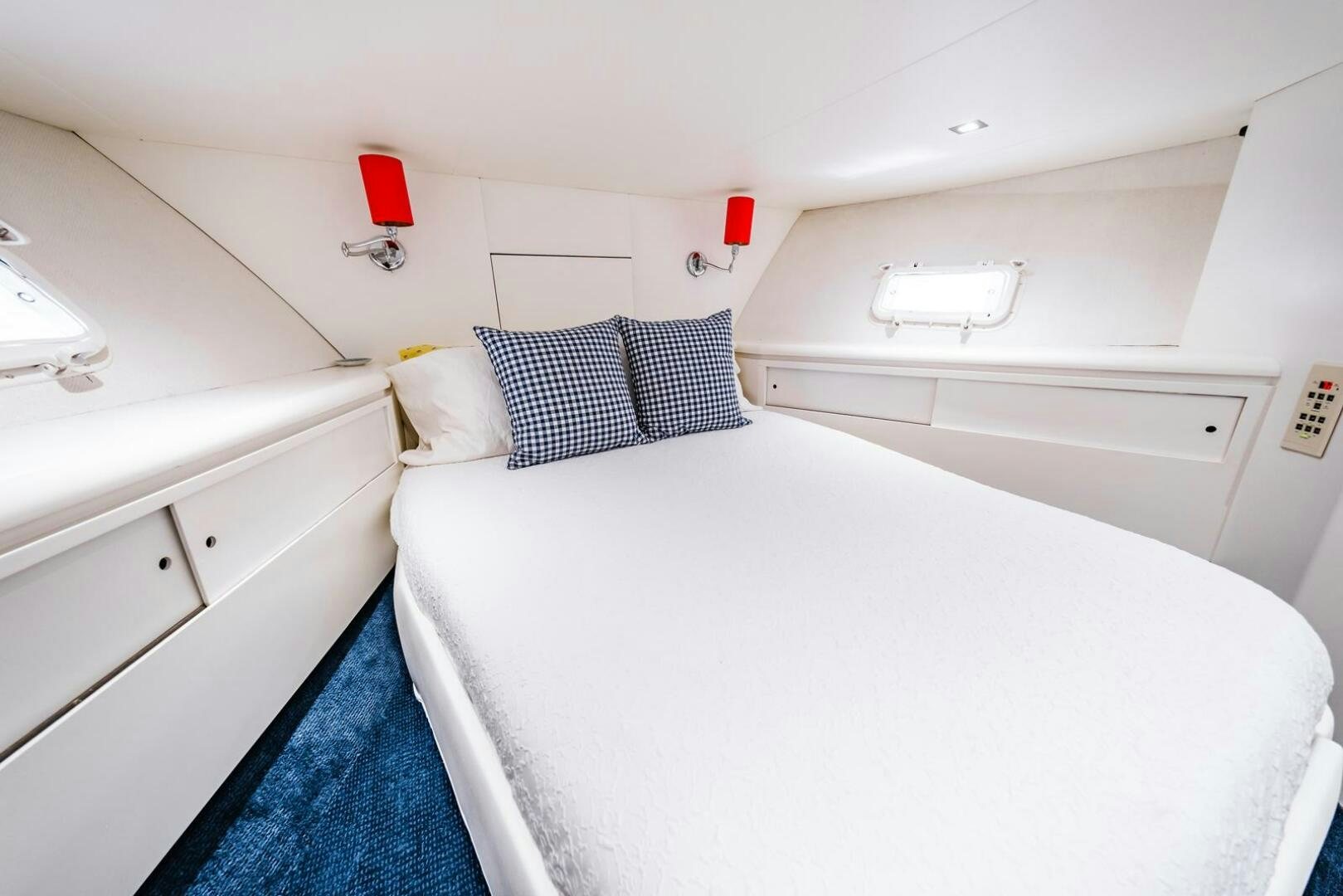 a white bedroom with a blue rug aboard GRACE Yacht for Sale