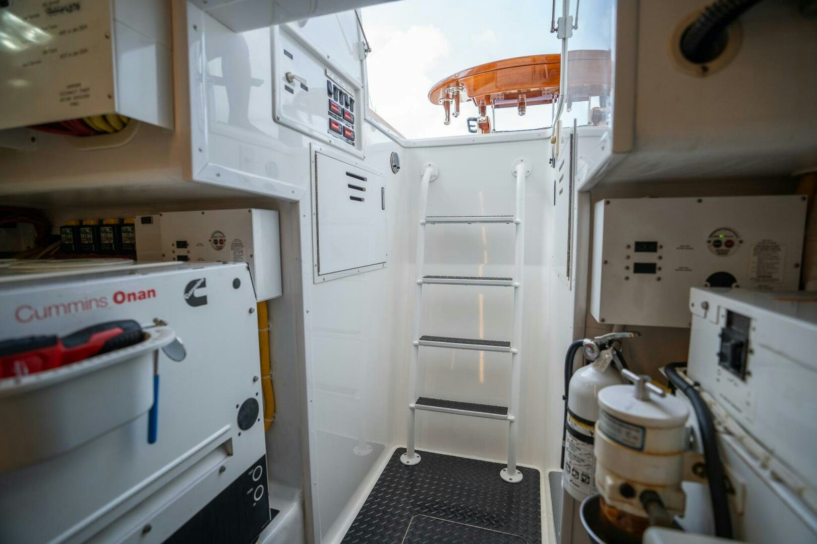 a room with white cabinets and a white shelf with a red and black object on it aboard VOODOO Yacht for Sale