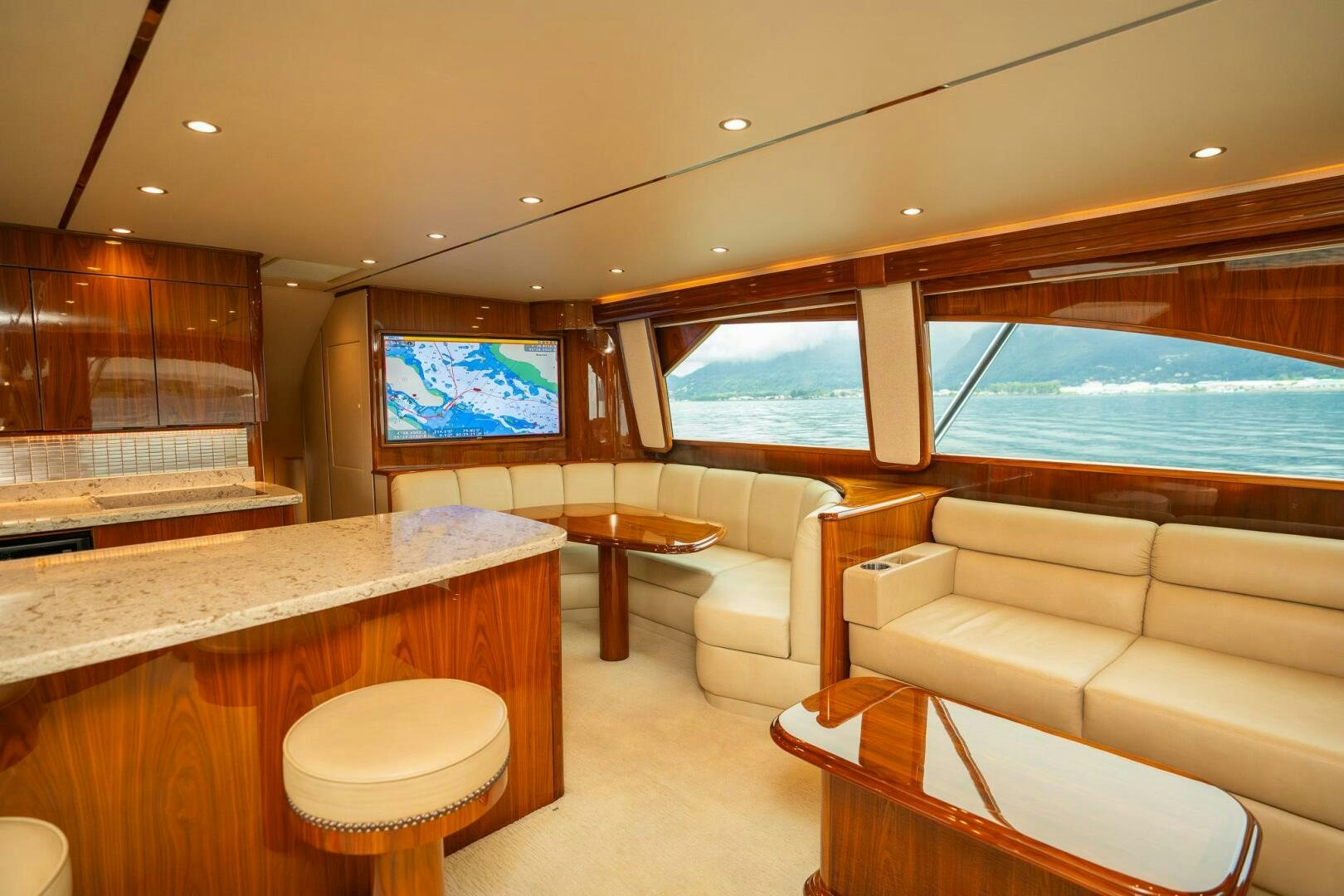 a room with a large window and a table with chairs and a view of the ocean aboard VOODOO Yacht for Sale