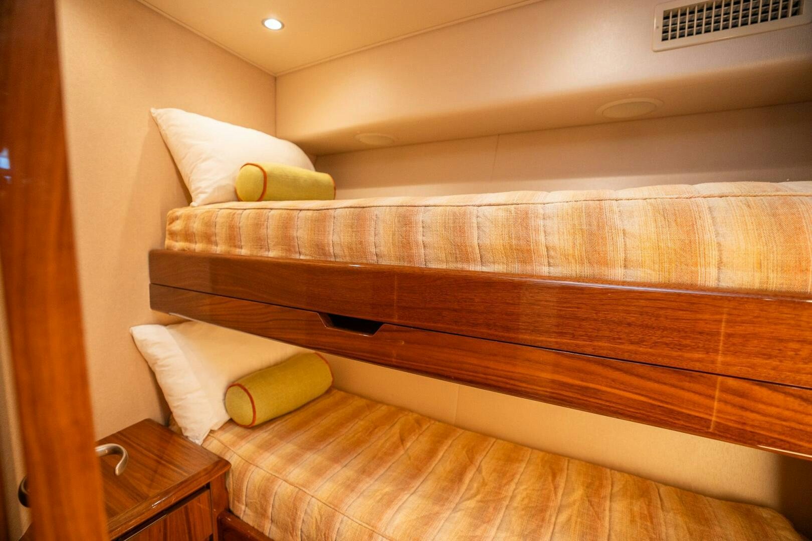a bed with a wooden headboard aboard VOODOO Yacht for Sale