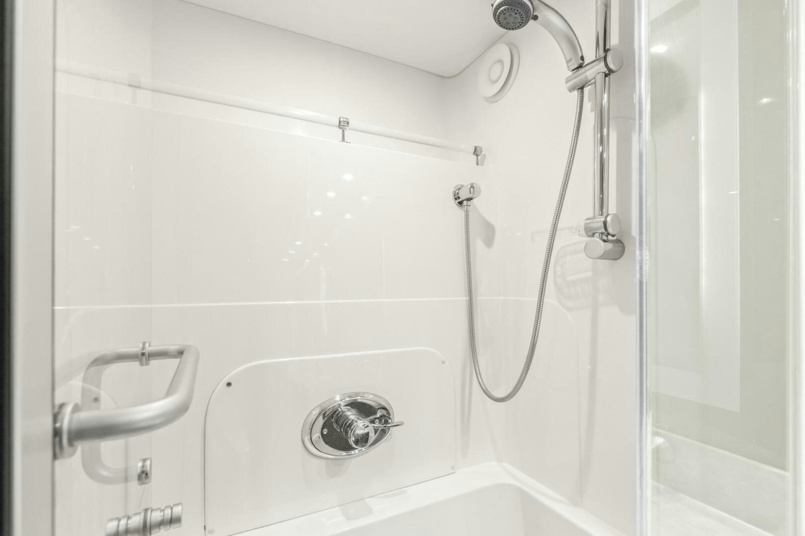 a shower with a white tile wall aboard HIGH LIFE Yacht for Sale