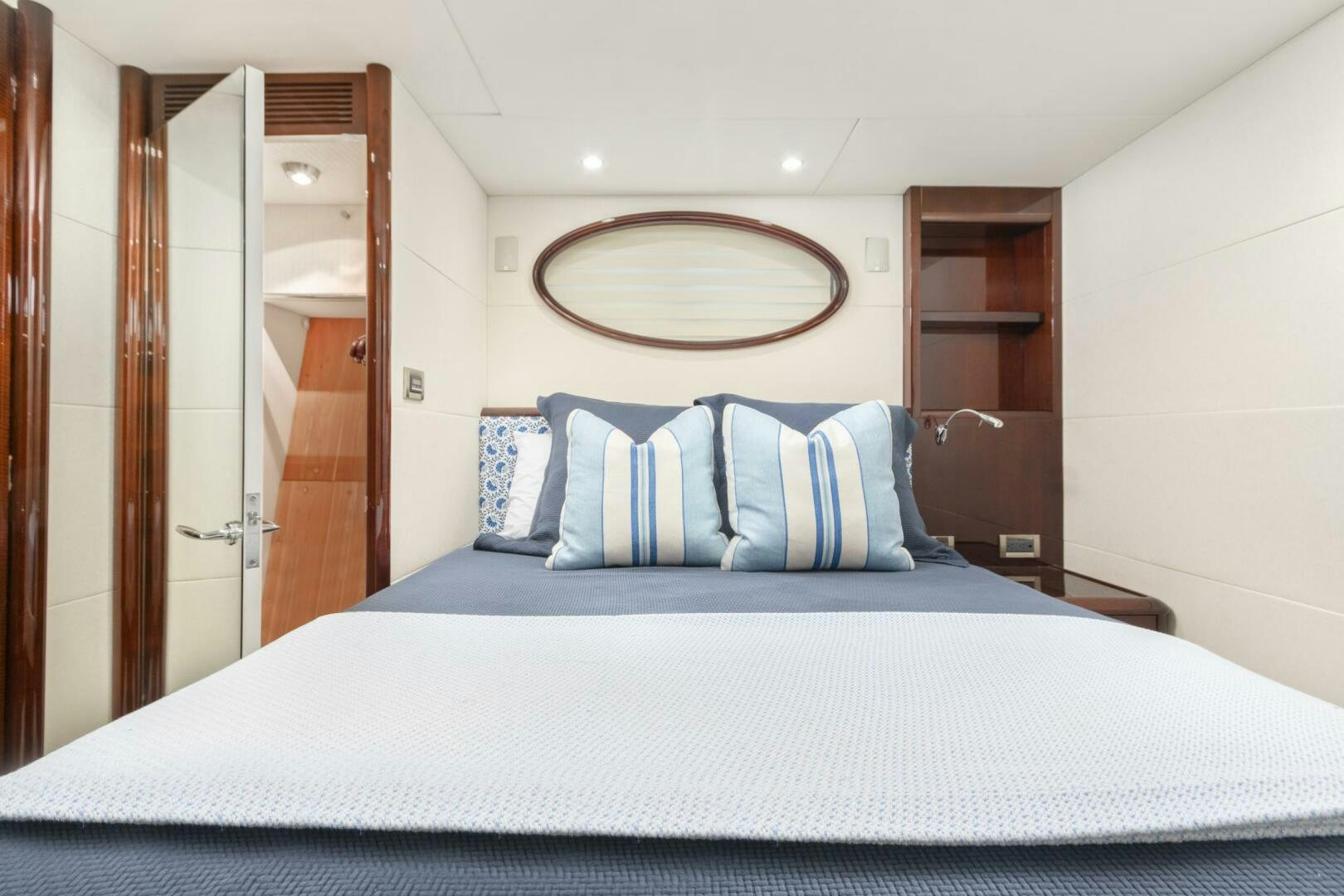 a bed with a white sheet and a mirror above it aboard HIGH LIFE Yacht for Sale