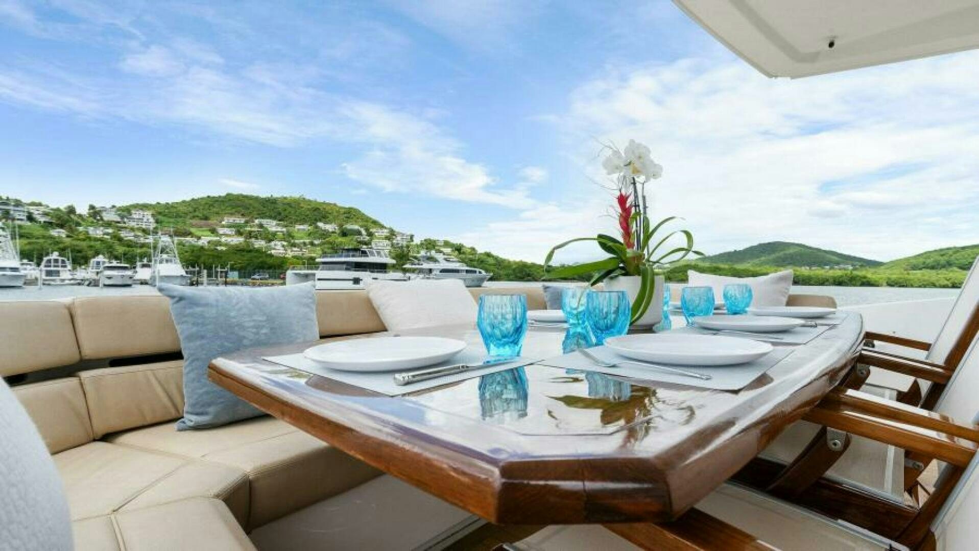 a table with chairs and a view of a body of water aboard AMORE Yacht for Sale