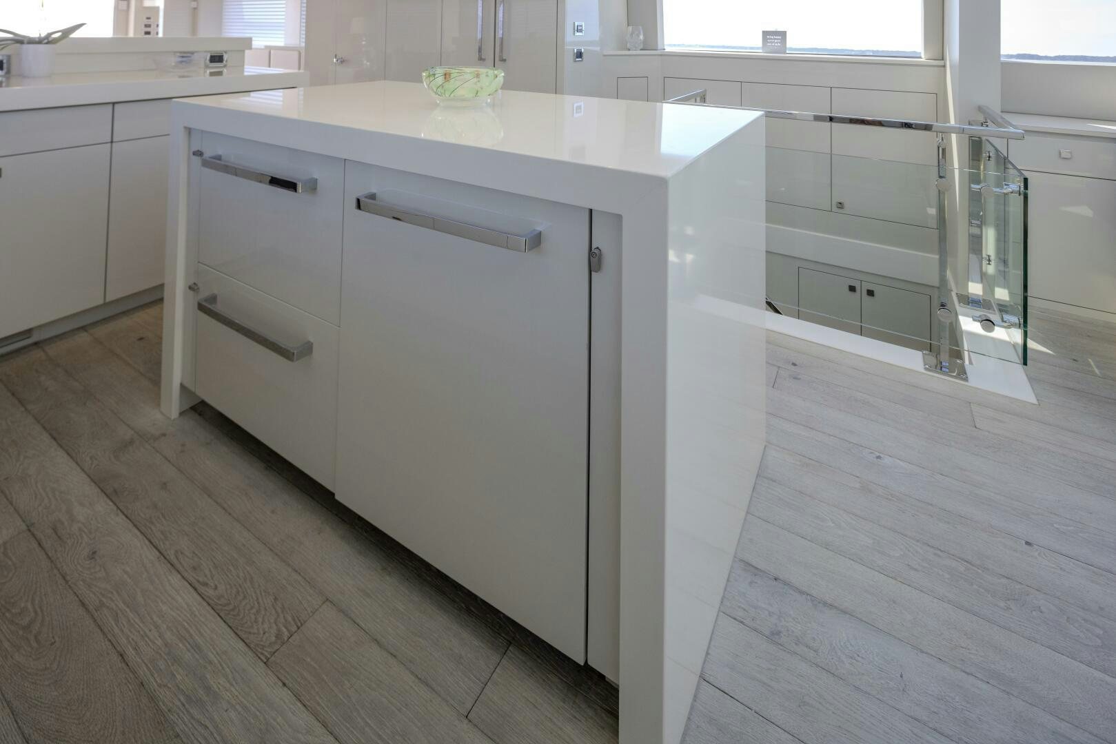 a white kitchen with a wooden floor aboard IMAGINE Yacht for Sale