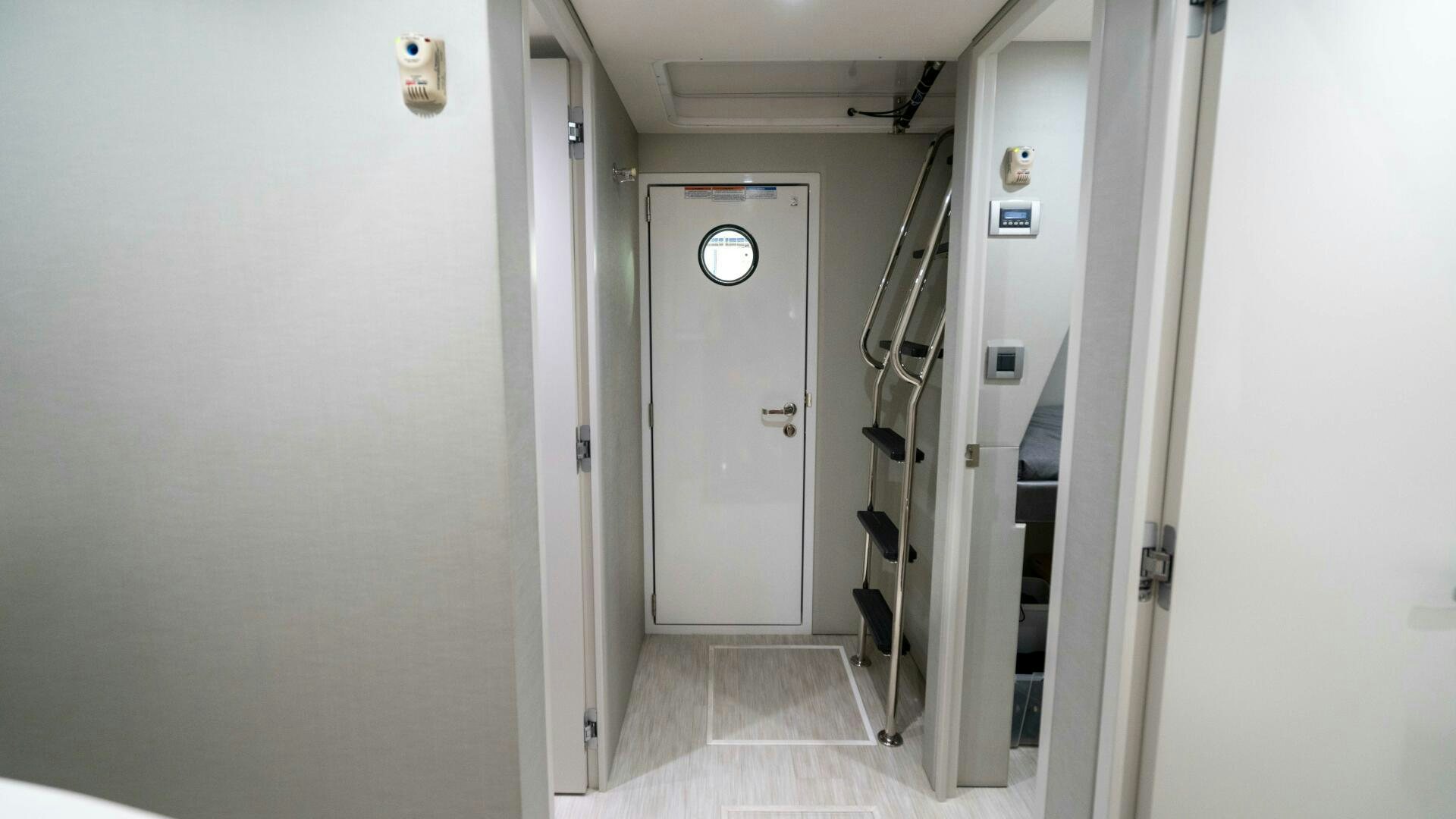 a hallway with a door and a ladder aboard IMAGINE Yacht for Sale