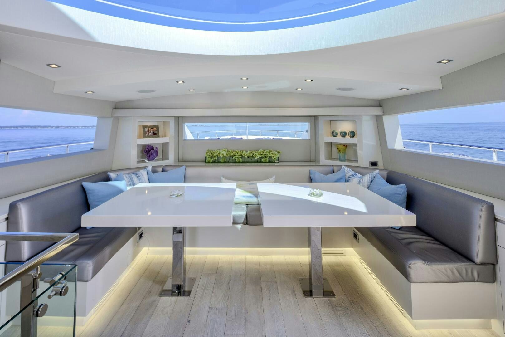 a room with a table and couch aboard IMAGINE Yacht for Sale