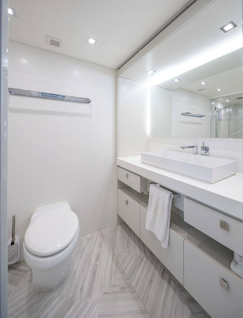 a bathroom with a sink toilet and a mirror aboard IMAGINE Yacht for Sale