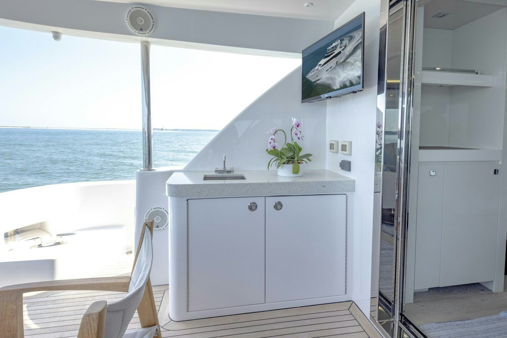 a white kitchen with a television on the wall aboard IMAGINE Yacht for Sale