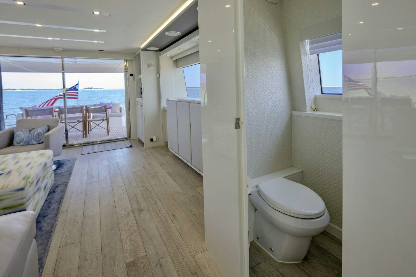 a room with a wood floor and a wood floor and a white toilet aboard IMAGINE Yacht for Sale