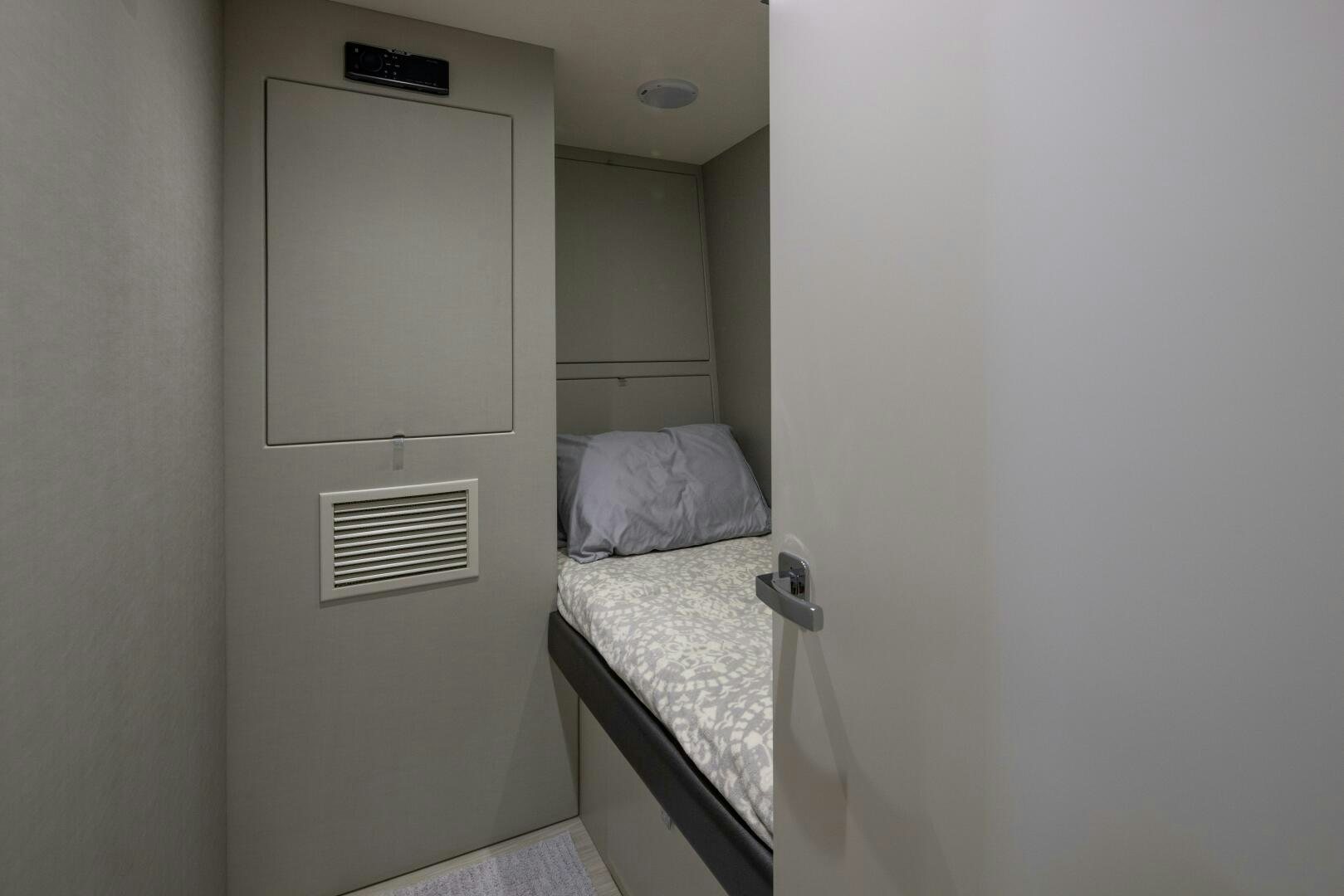 a small bedroom with a mirror aboard IMAGINE Yacht for Sale