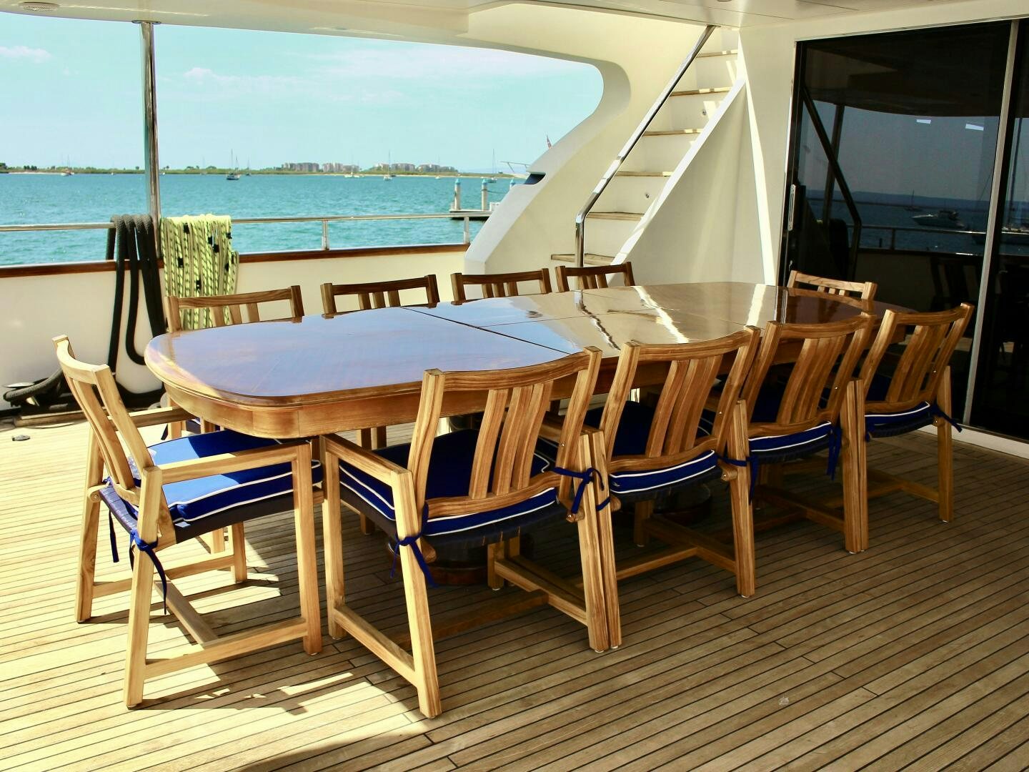 a deck with a table and chairs aboard GARI Yacht for Sale