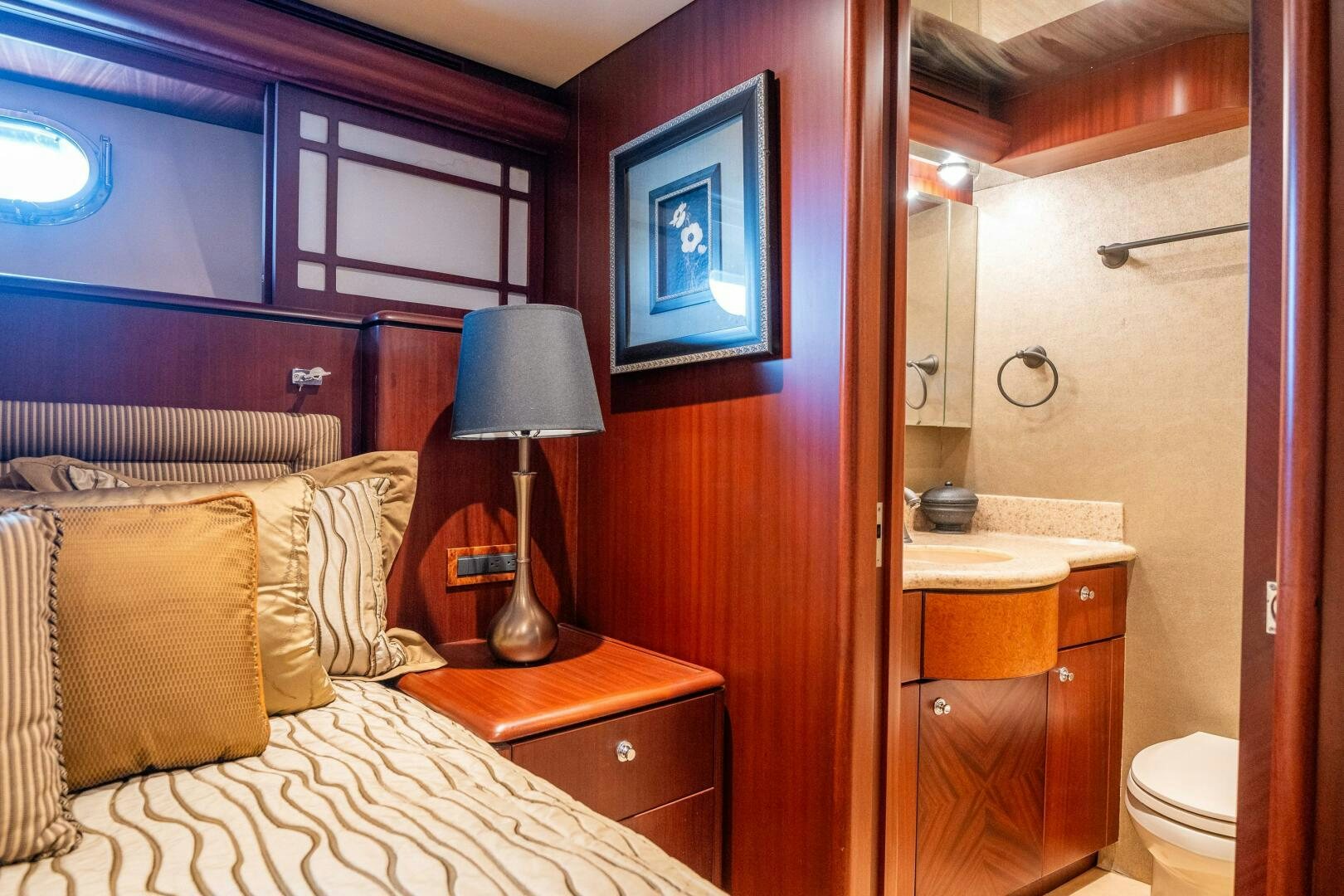 a bedroom with a bed and a lamp aboard E Yacht for Sale