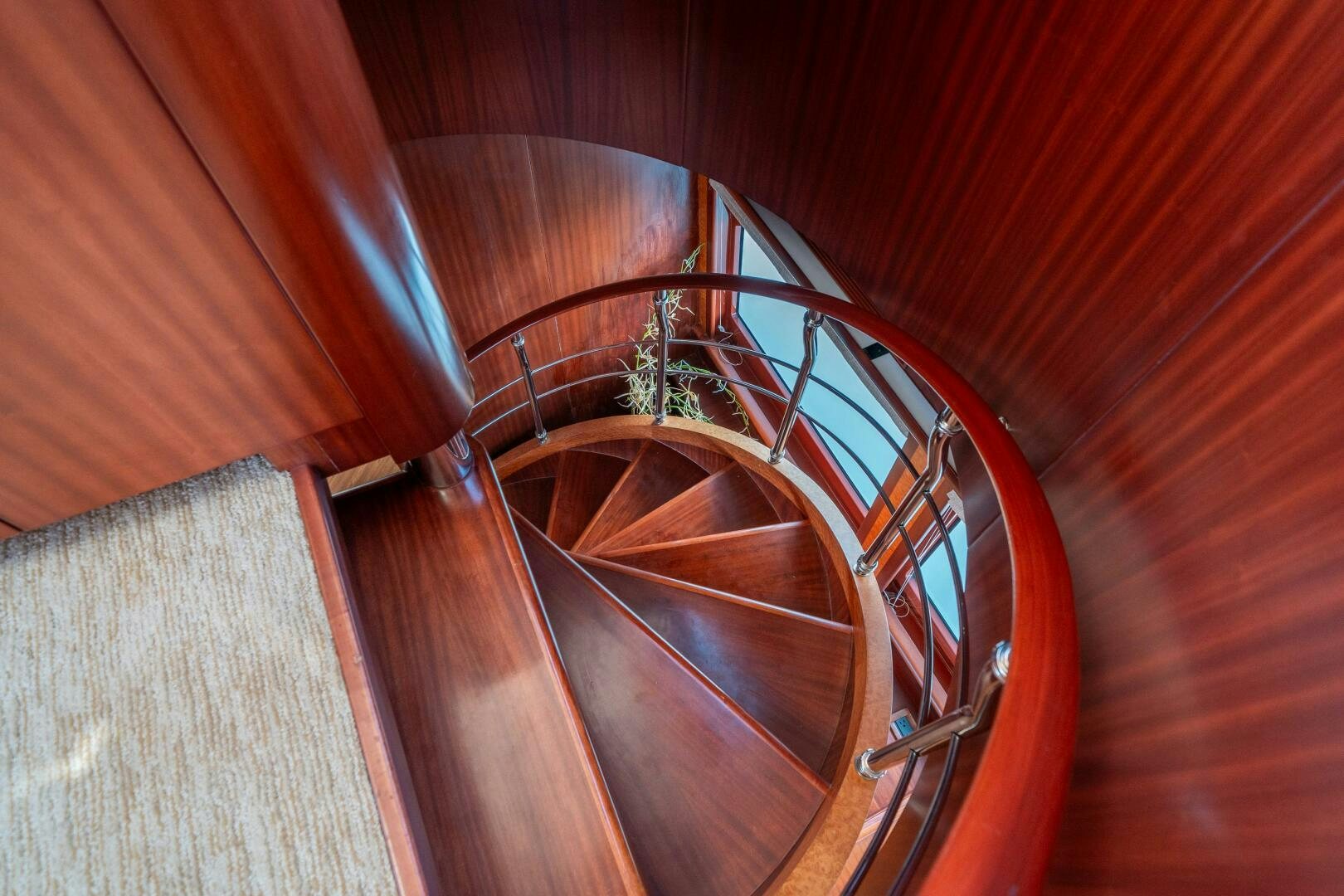 a wooden spiral staircase aboard E Yacht for Sale