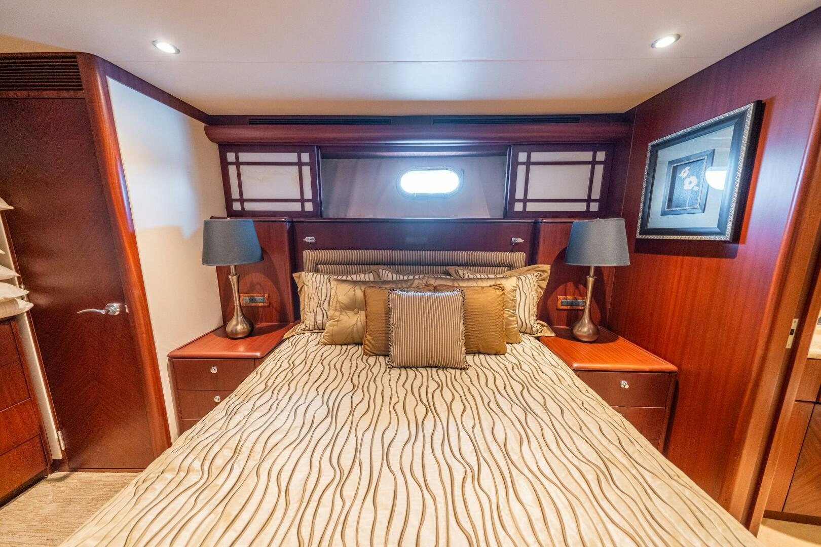 a bed with a pillow and a desk in a hotel room aboard E Yacht for Sale