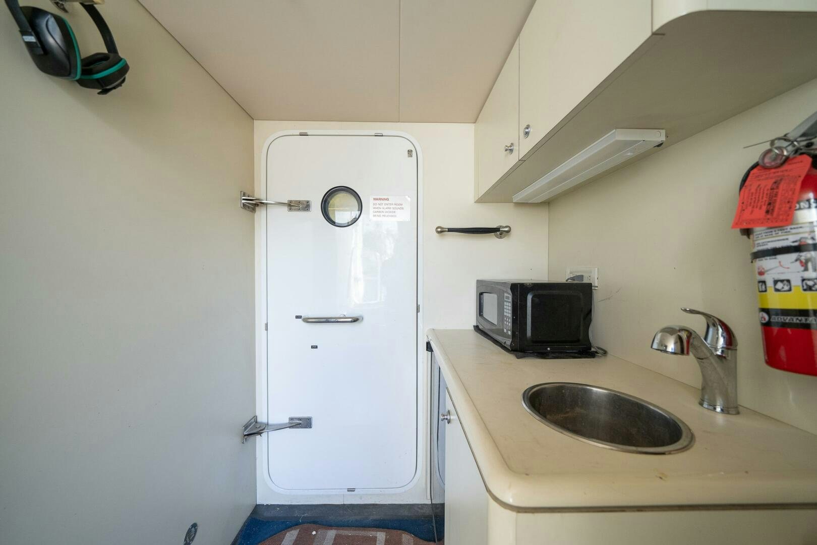a small kitchen with a white refrigerator aboard E Yacht for Sale
