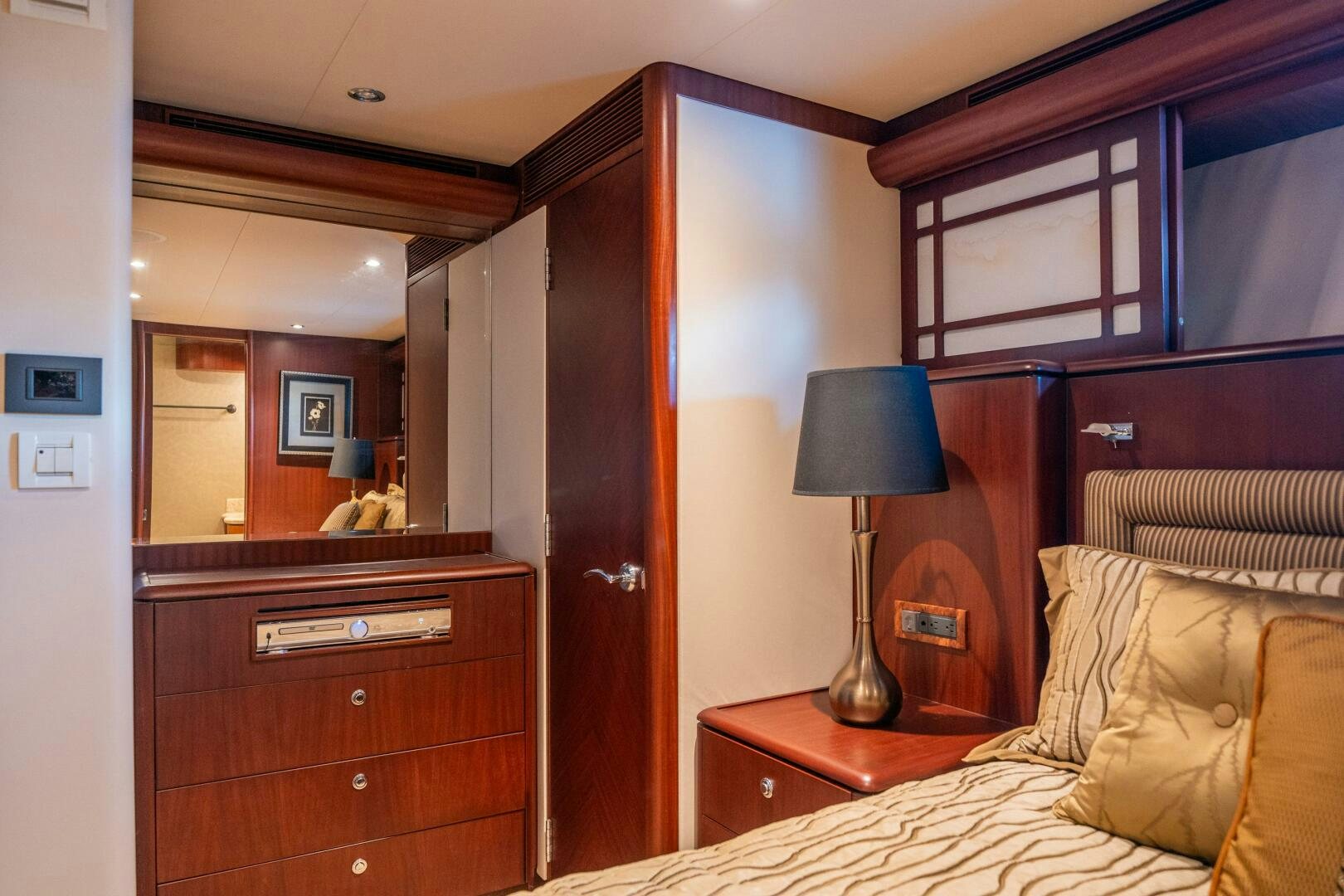 a bedroom with a bed and a lamp aboard E Yacht for Sale