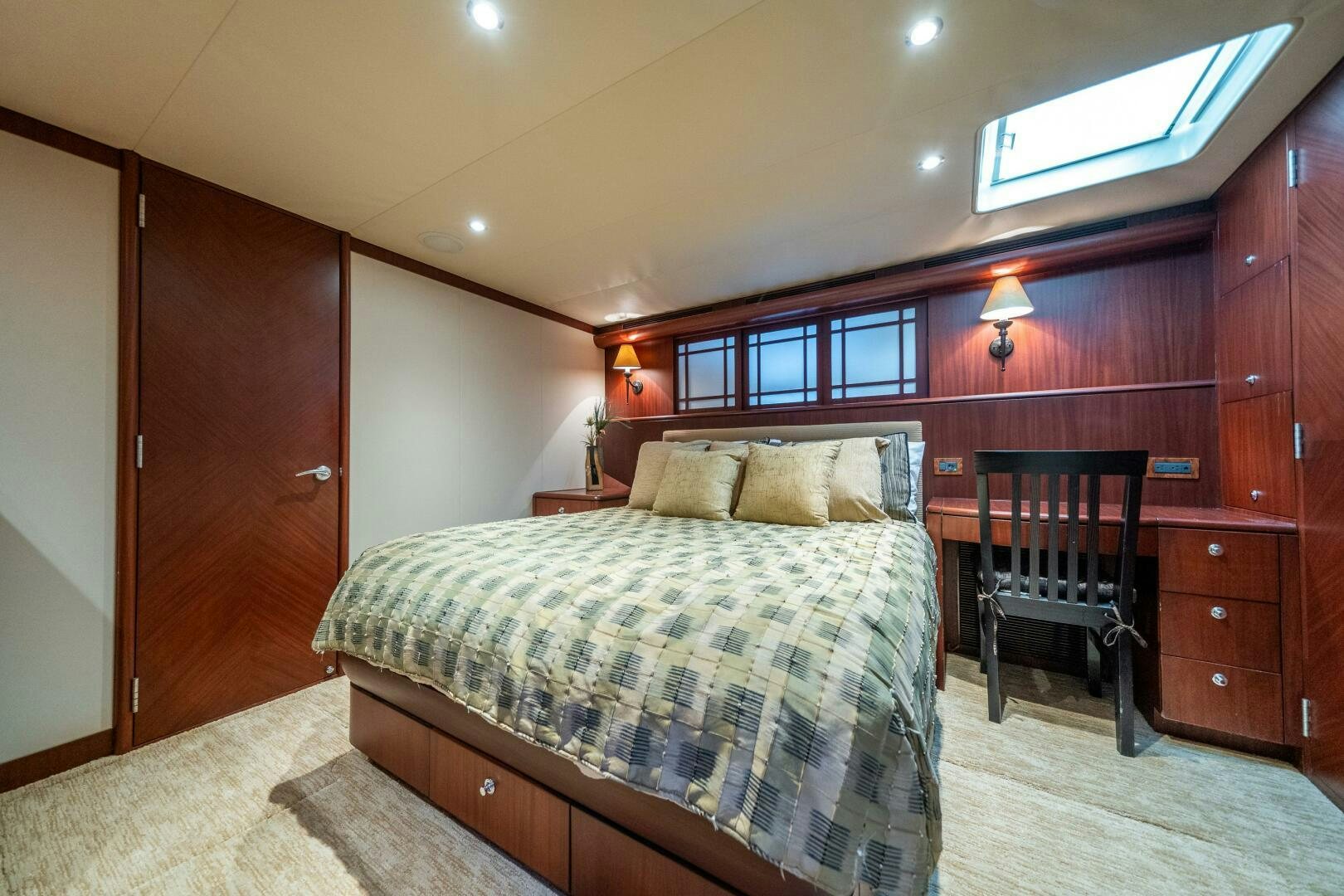 a bedroom with a bed and a chair aboard E Yacht for Sale