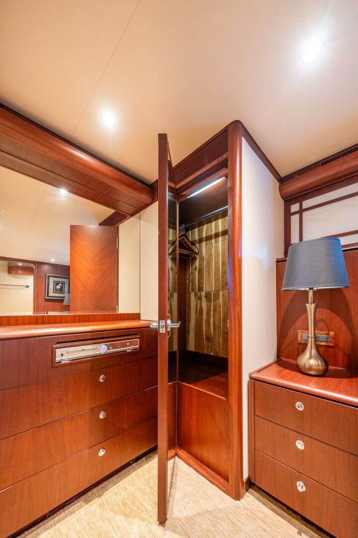 a room with a wood cabinet and a lamp on a stand aboard E Yacht for Sale