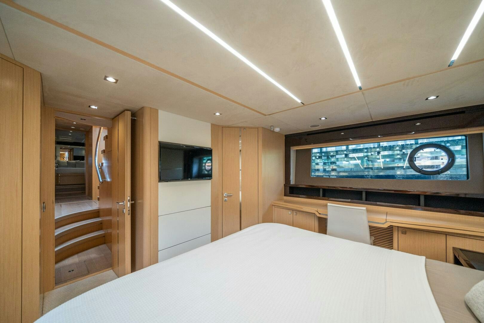 a room with a bed and a television aboard MYLE Yacht for Sale