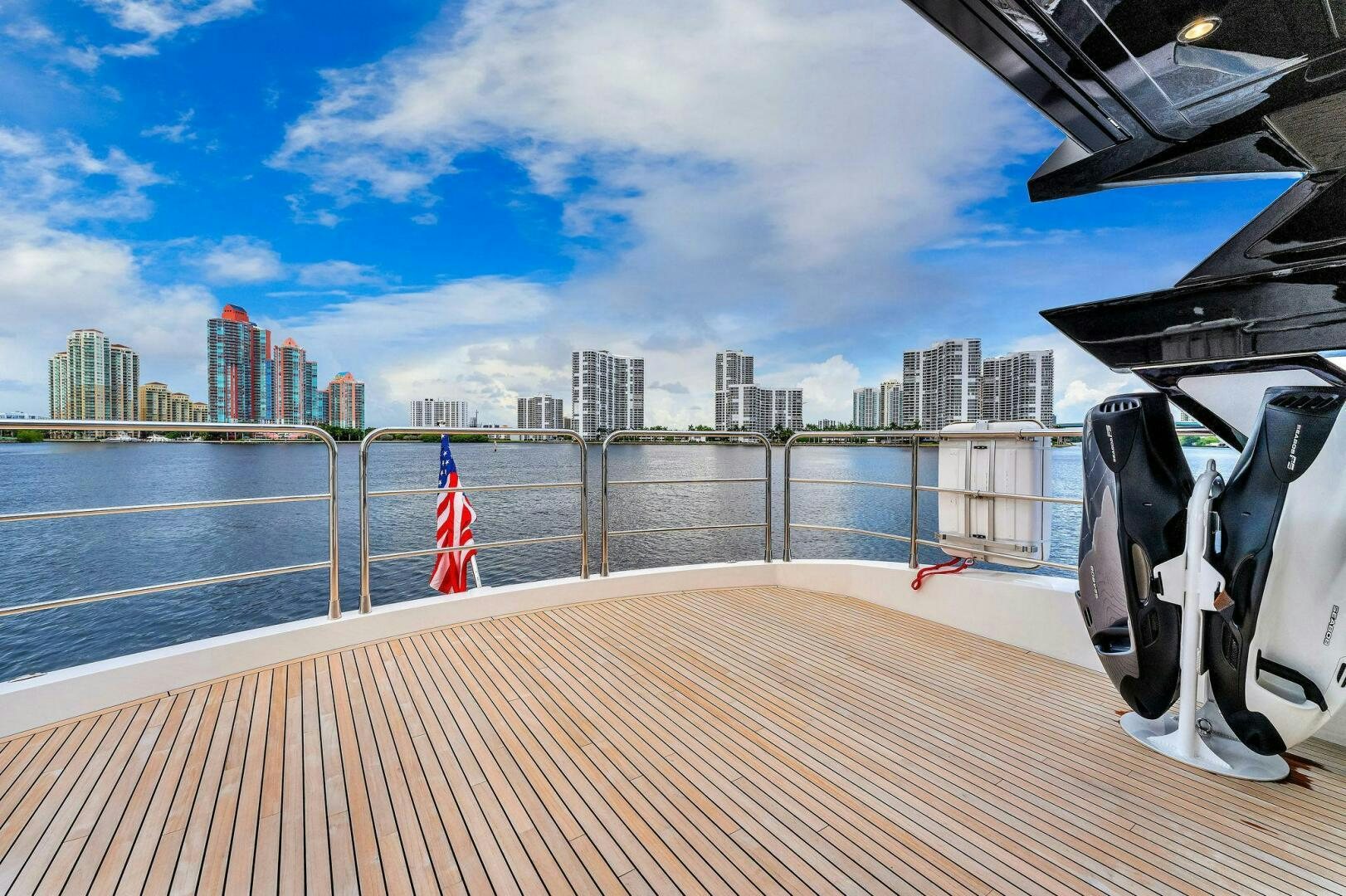 a deck with a flag and a city in the background aboard YOU AND ISLANDS Yacht for Sale