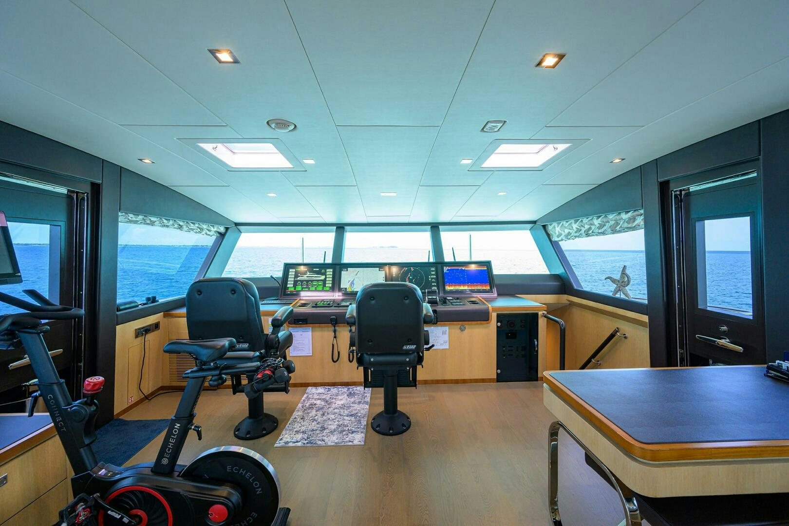 a room with a desk and chairs aboard AQUA LIFE Yacht for Sale