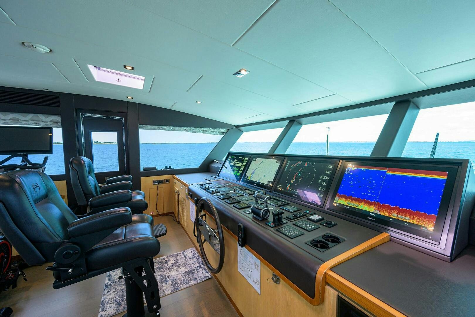 a room with several monitors and a chair aboard AQUA LIFE Yacht for Sale