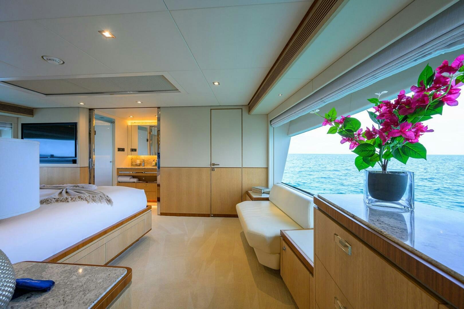 a large living room with a large glass vase with flowers in it aboard AQUA LIFE Yacht for Sale