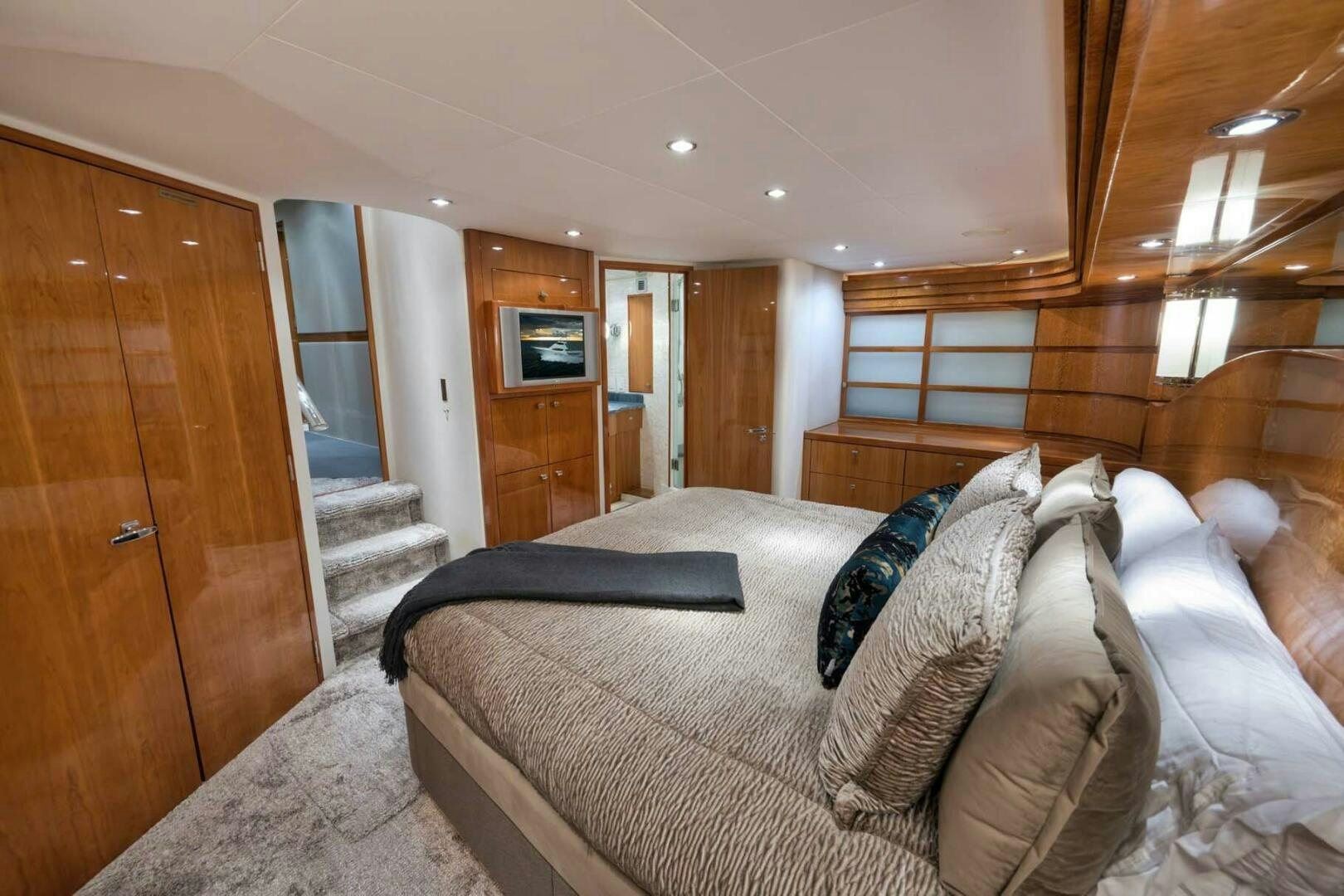 a bedroom with a bed and a wood door aboard REEL TRADER Yacht for Sale