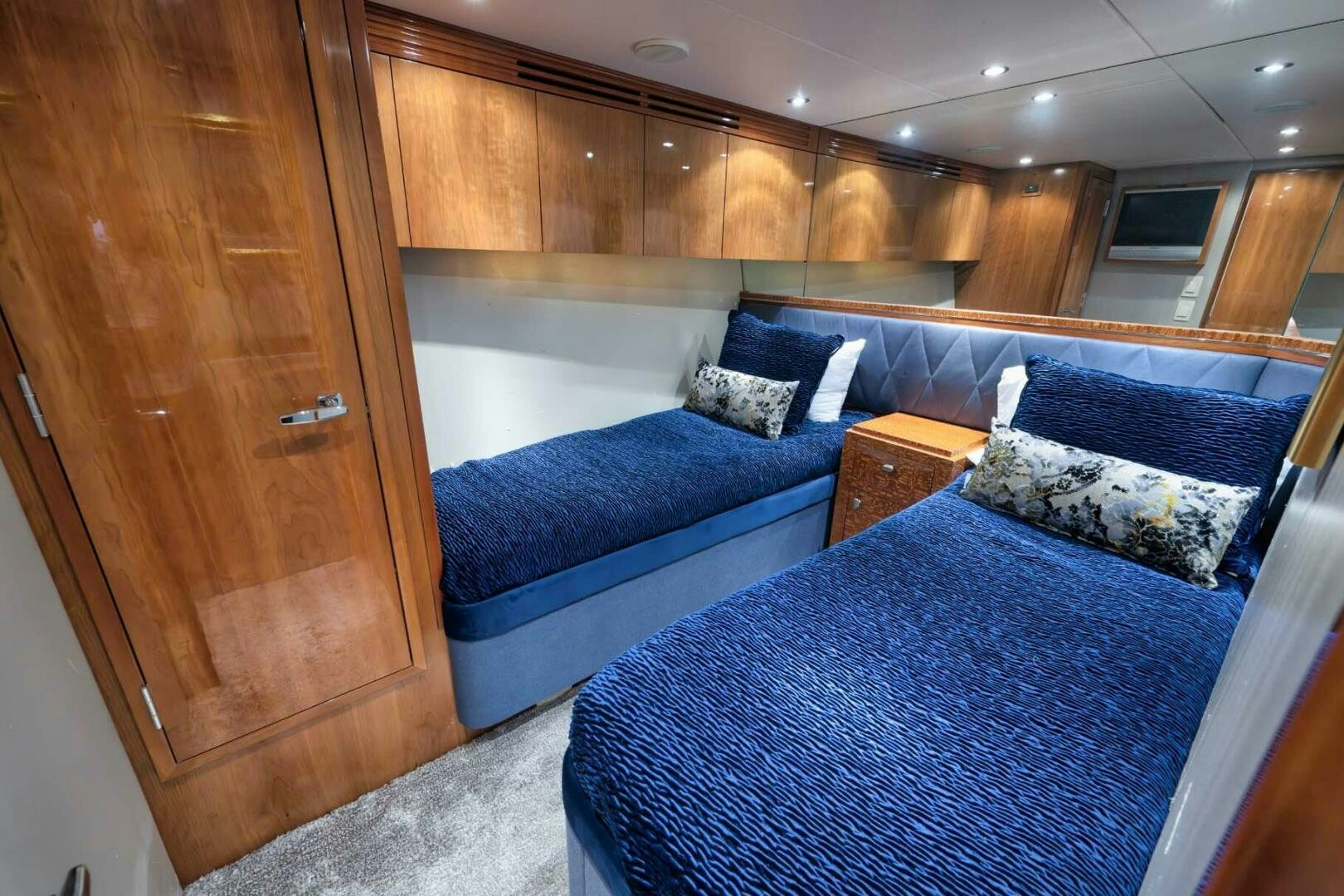 a room with a bed and a wood cabinet aboard REEL TRADER Yacht for Sale