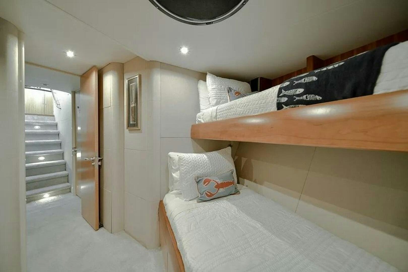 a bedroom with a bed and a wood railing aboard CERCA TROVA Yacht for Sale