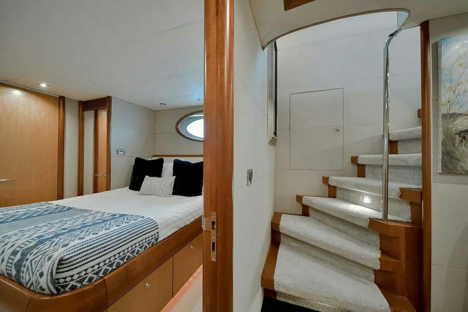 a bedroom with a bed and a staircase aboard CERCA TROVA Yacht for Sale