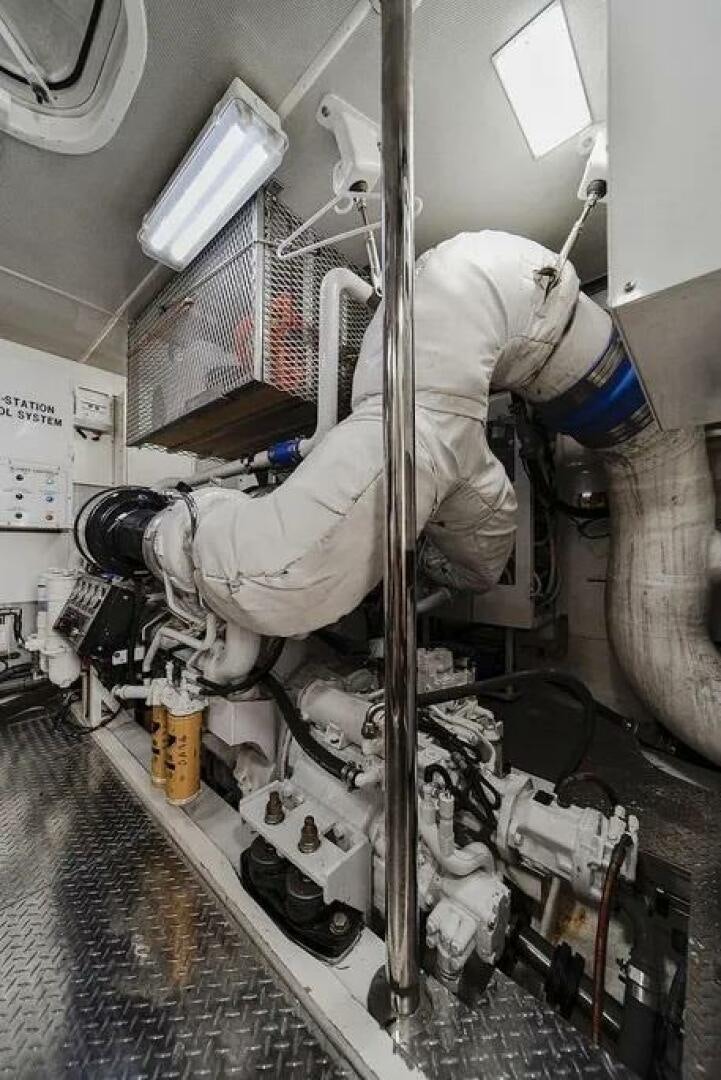 a person in a white suit working on a machine aboard CERCA TROVA Yacht for Sale