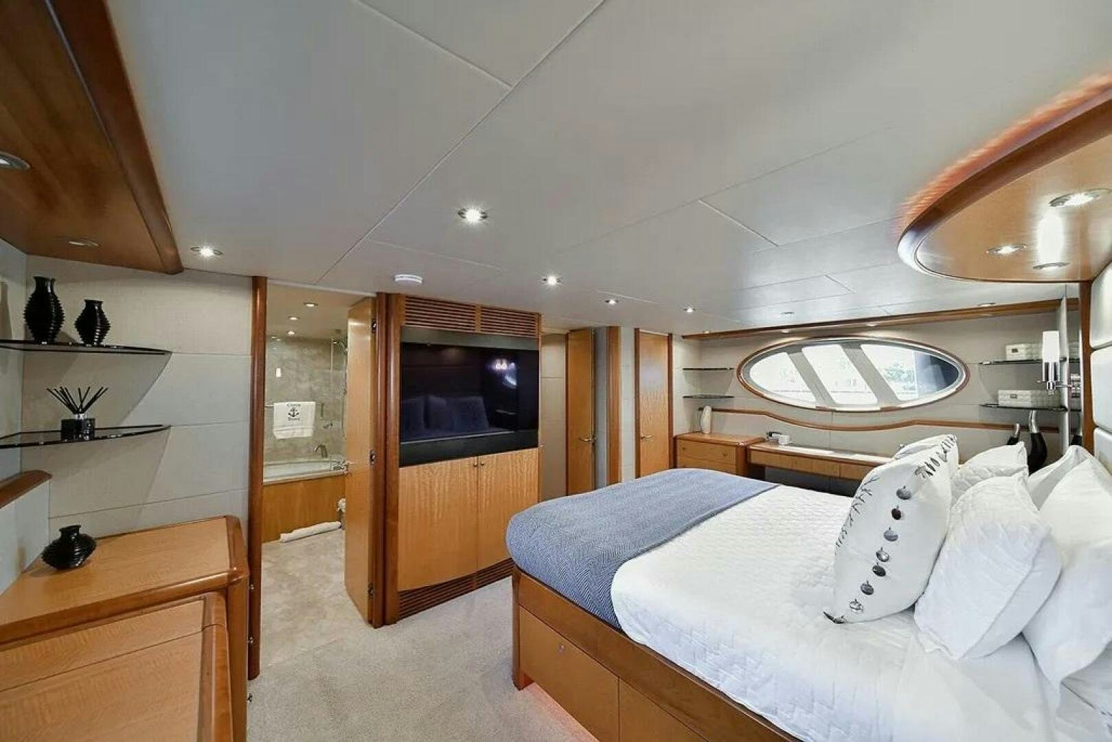 a bedroom with a bed and a mirror aboard CERCA TROVA Yacht for Sale