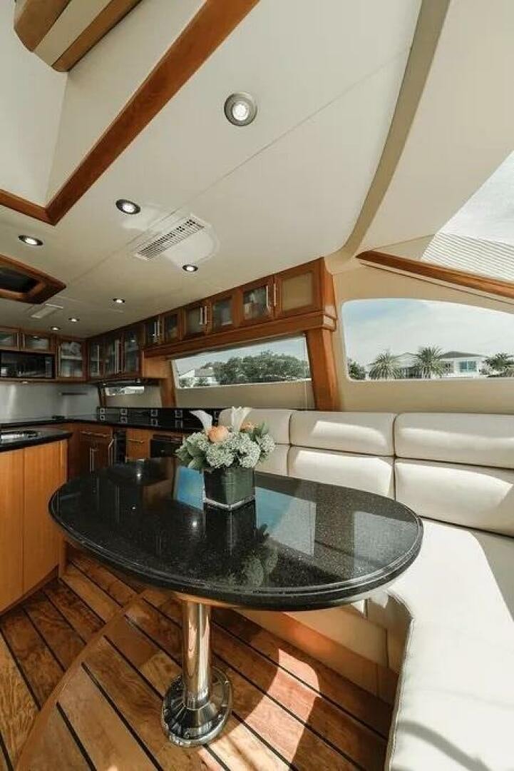 a room with a table and couch aboard CERCA TROVA Yacht for Sale