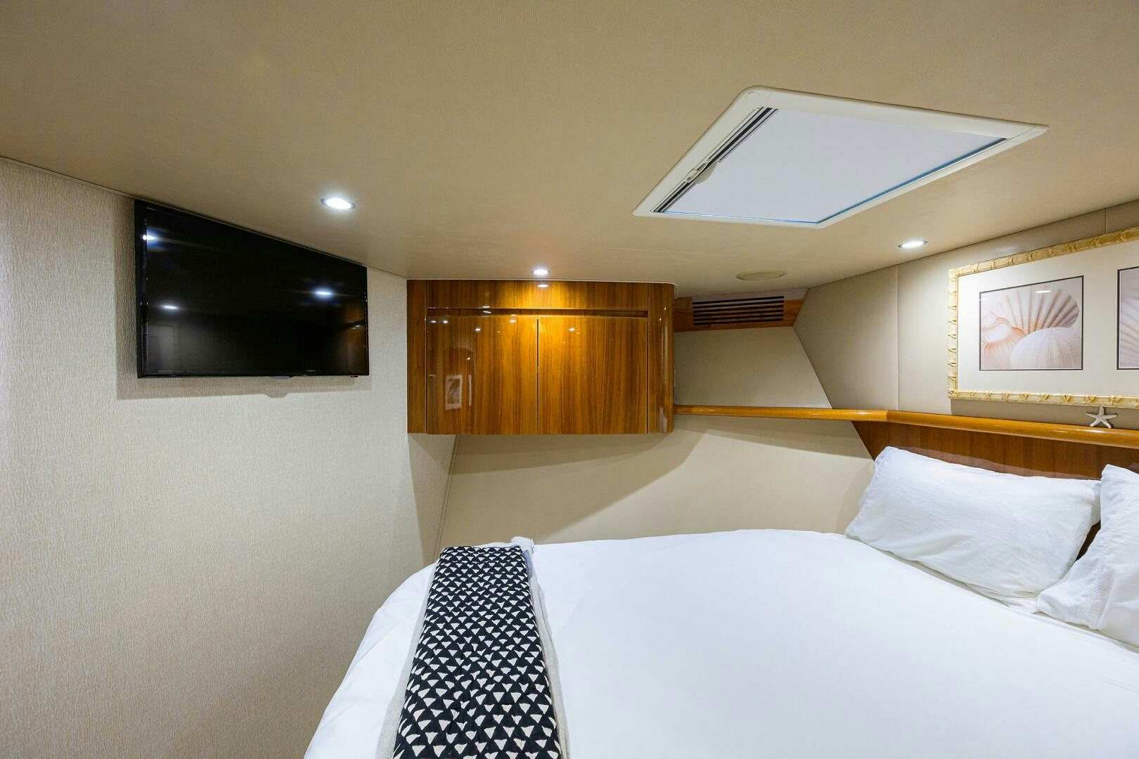 a room with a bed and a television aboard JUST CHILLIN Yacht for Sale