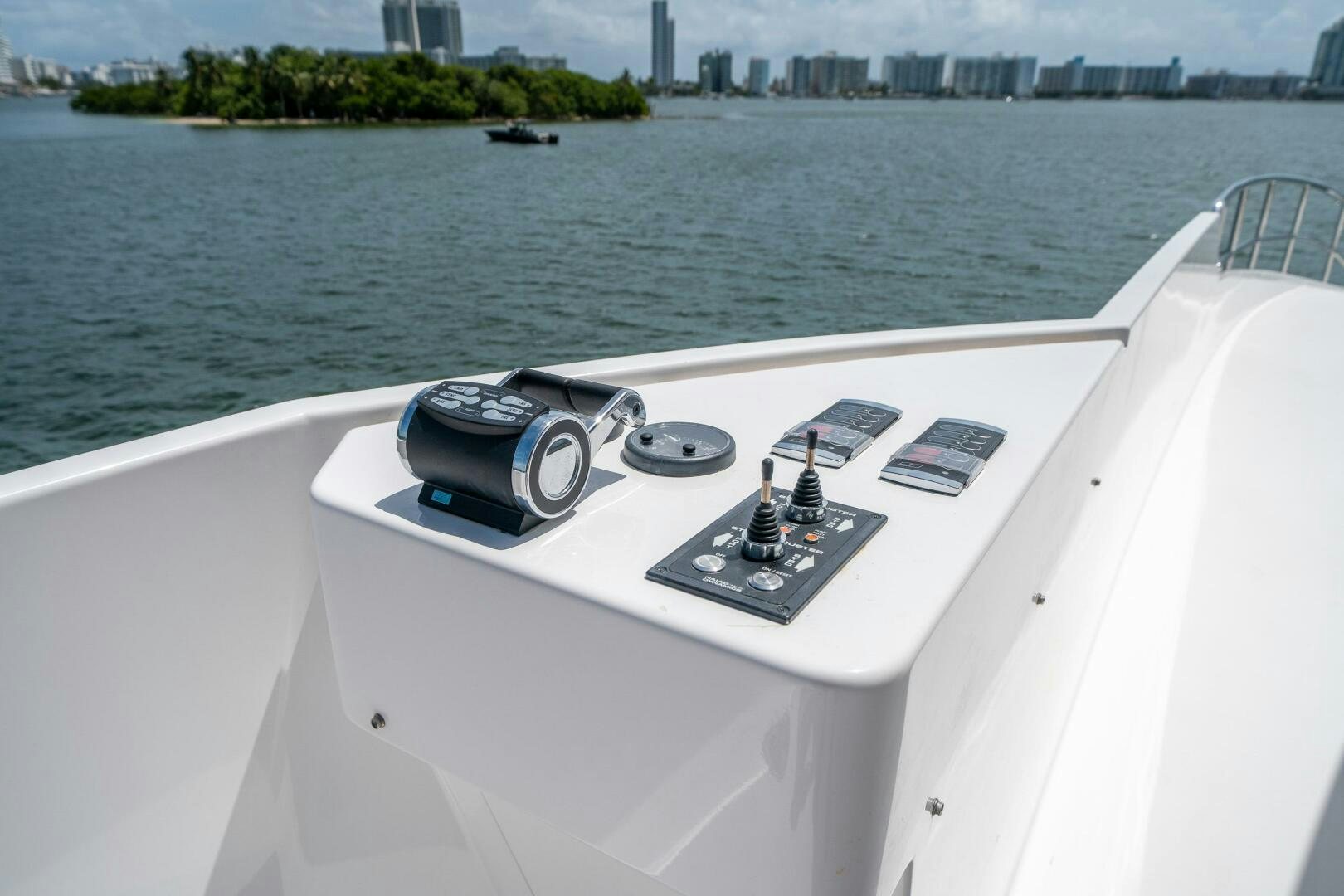 a boat with a steering wheel and a city in the background aboard DAY ONE Yacht for Sale