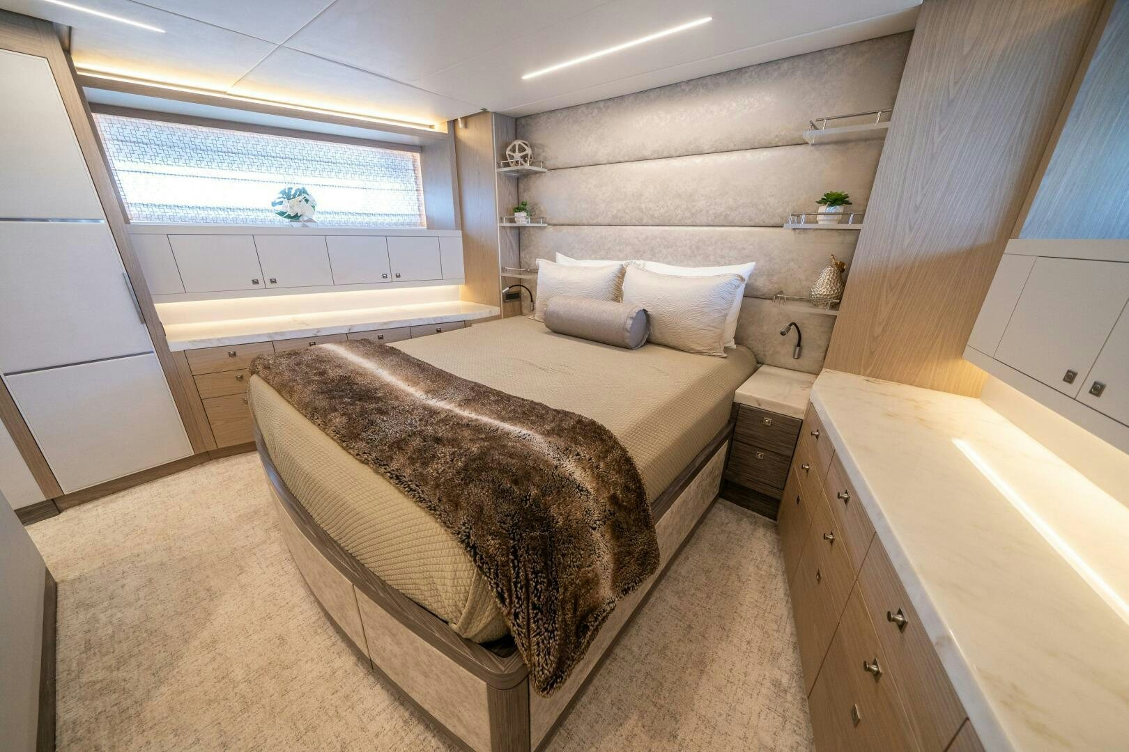 a modern looking bedroom with a large bed and a wooden shelf aboard DAY ONE Yacht for Sale