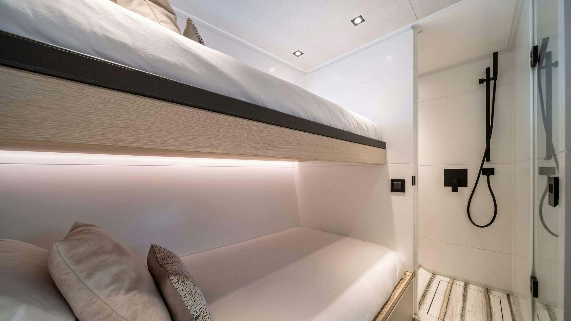 a bed with a white wall aboard FELLOWSHIP II Yacht for Sale